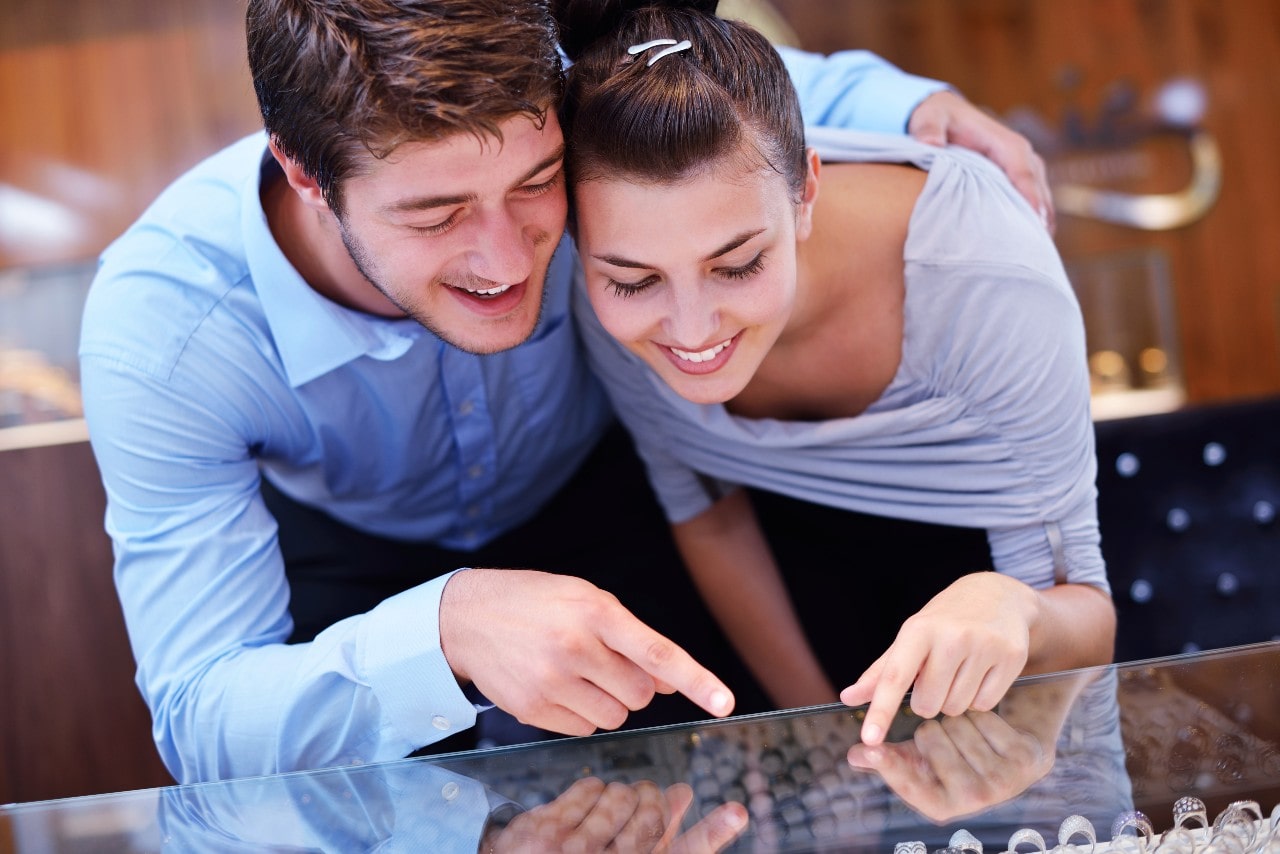 a couple looking at engagement rings and rings