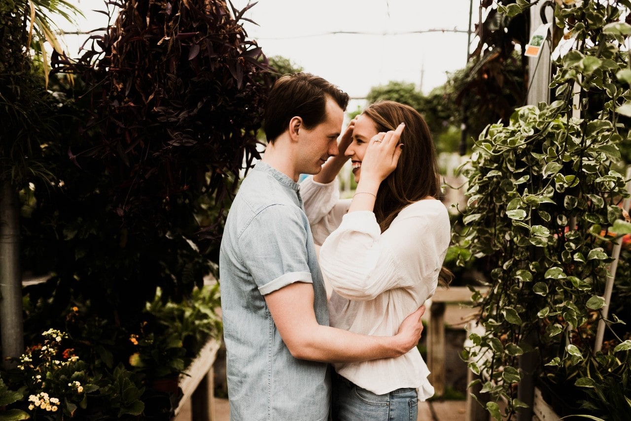 Couple hugging in a plant store right after the man proposed