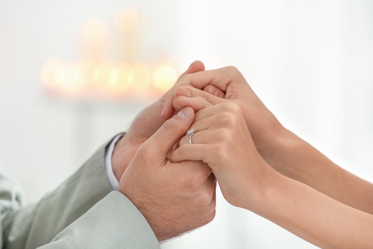 A couple holding hands right after they have become engaged.