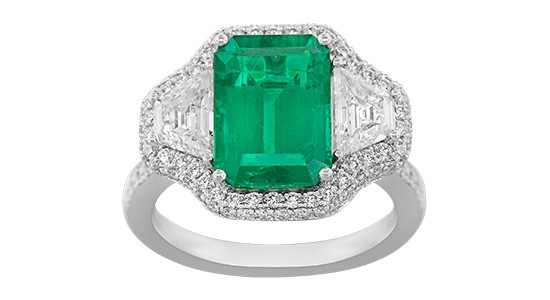 a white gold fashion ring featuring a large emerald and diamond accents