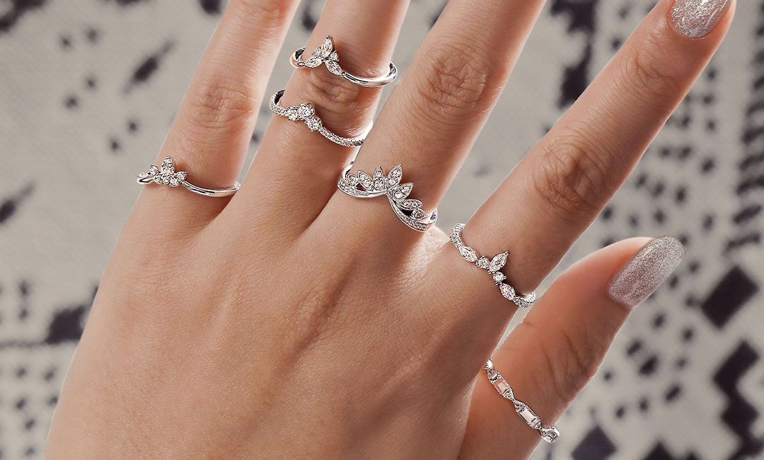 several Gabriel & Co. diamond rings on a woman’s hand