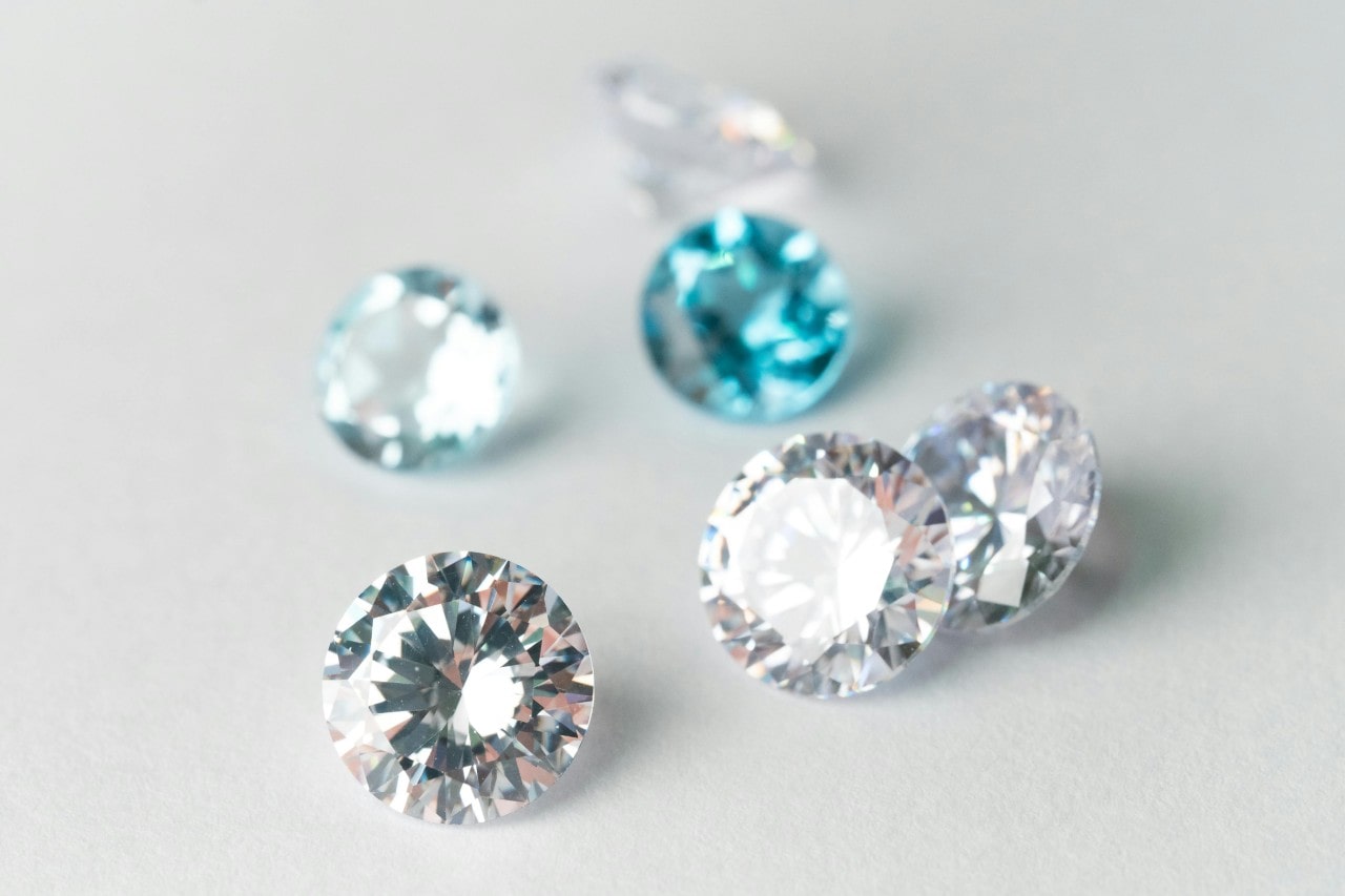 A close-up of six brilliant round-cut diamonds on a pale background.