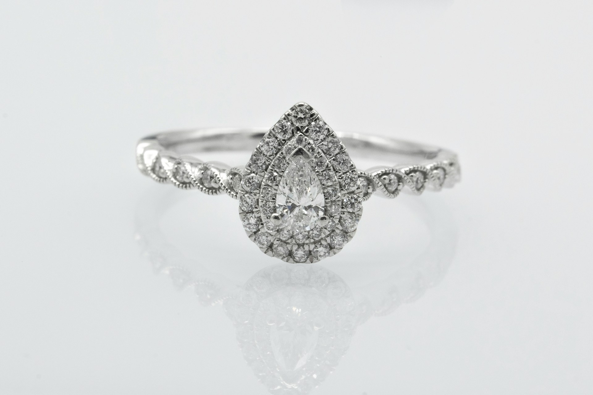 a white gold engagement ring with a pear shape center stone